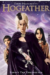 A woman in a dark cape holding a large silver staff stands before two children, set against a mystical purple sky and snowy landscape—an adventure reminiscent of classic sci-fi books. The title Hogfather appears at the top.