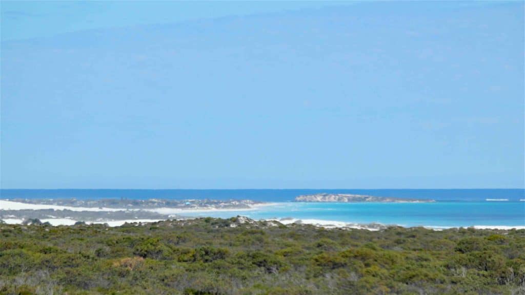 a view of the coastline with its blue water and white sand