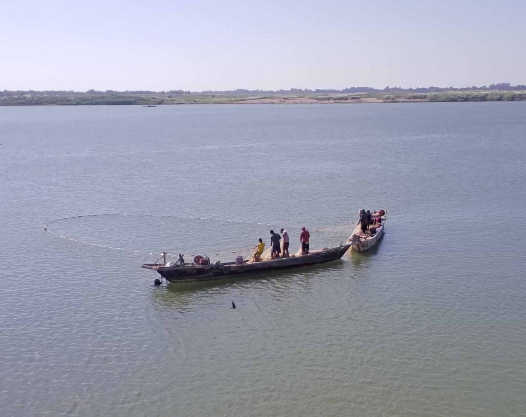 Fishermen bringing a net from their boat