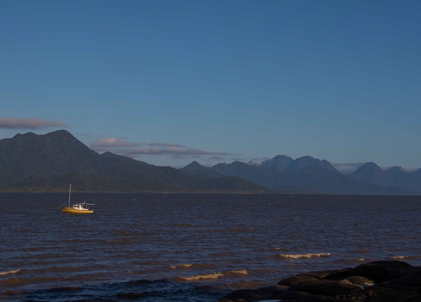 A view of Hinchinbrook Island's mountainous terrain  taken from the beach at Cardwell at sunset