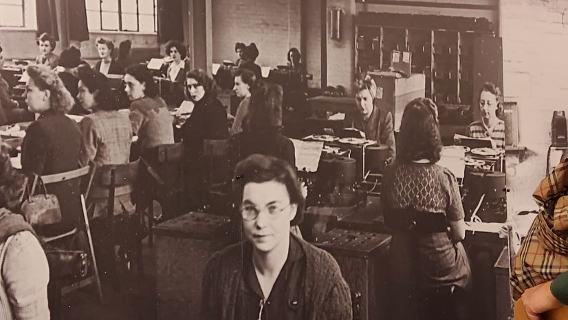 A black and white photo of female workers sitting at desks at Bletchley Park