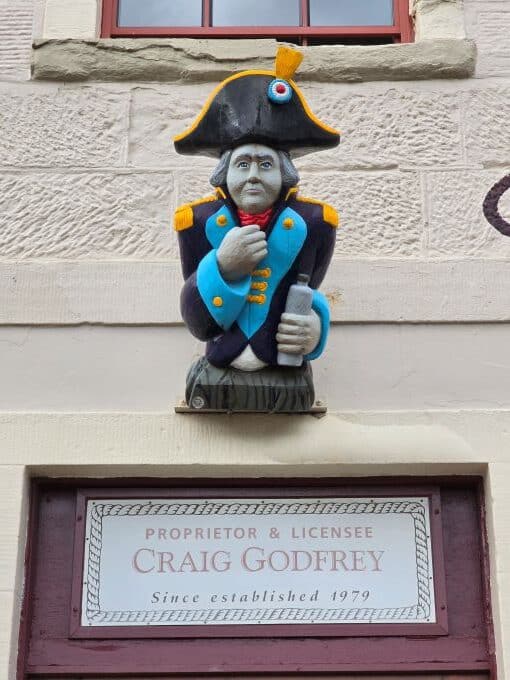 Drunken Admiral sign above the restaurant. A painted carving of a man in an admiral's uniform