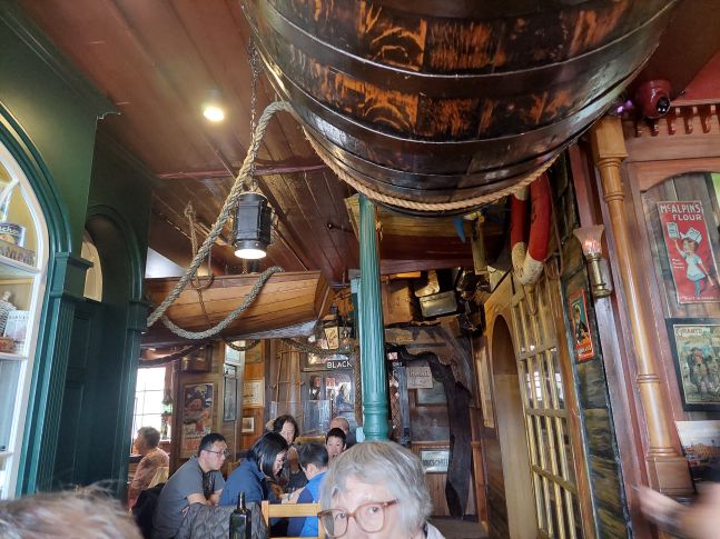 Inside Drunken Admiral showing bric-a-brac, sails, boats, and crowded seating