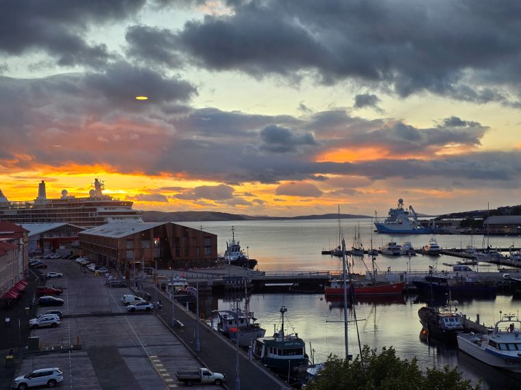 View from room at dawn. Constitution dock in Hobart with the sun rising through cloud