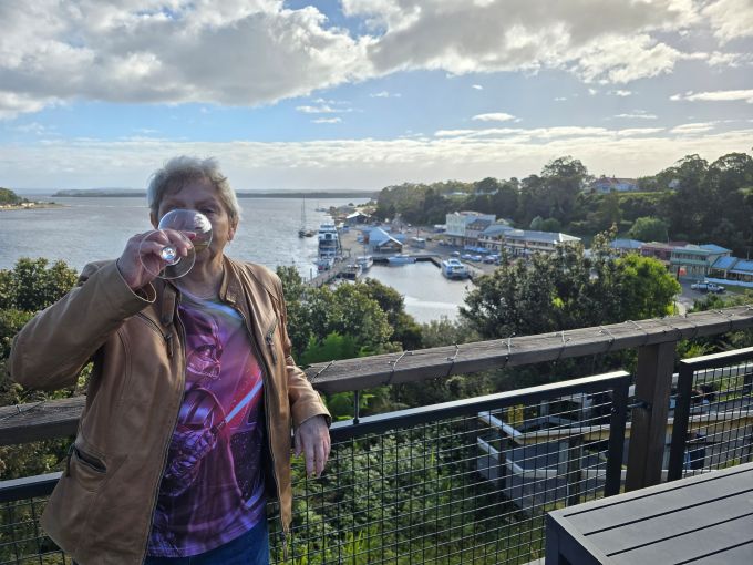 Overlooking Macquarie Harbour, a woman drinking wine