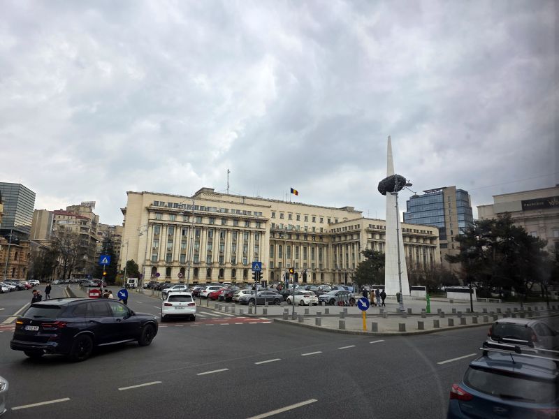 Bucharest revolution square with a large solid office building 
