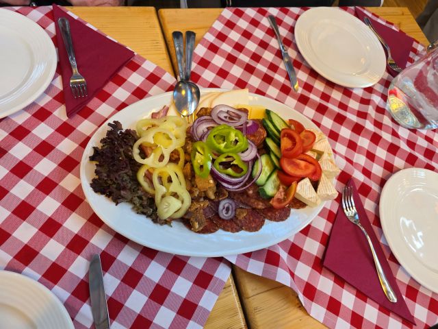 Tasting platter at the Budapest market featuring sausage, peppers, cheesem and vegetables