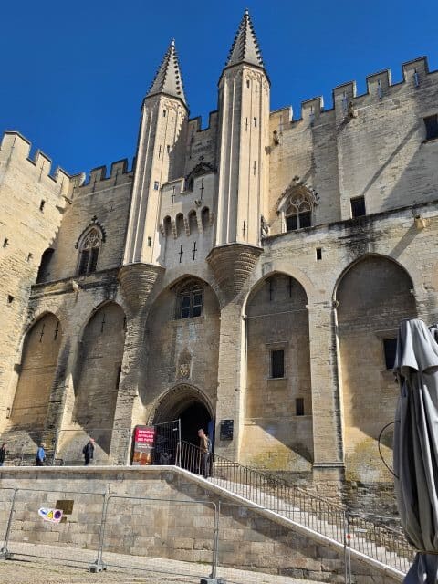 Avignon papal palace front showing two towers and steps leading to the entrance