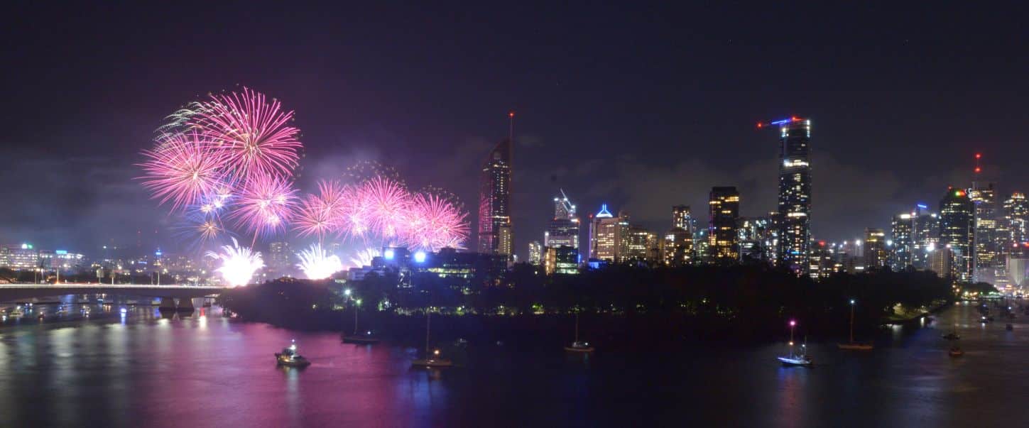 Fireworks explode over the river and the city of Brisbane